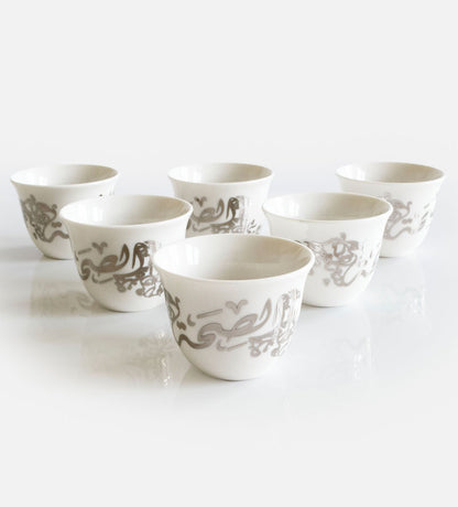 Elegant silver qahwa coffee cups featuring Arabic calligraphy designs by Kashida.