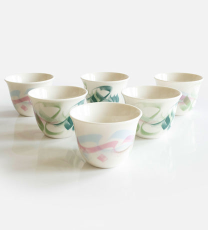 Pastel colored arabic coffee cups featuring Arabic calligraphy done by hand with elegant watercolor brushstrokes