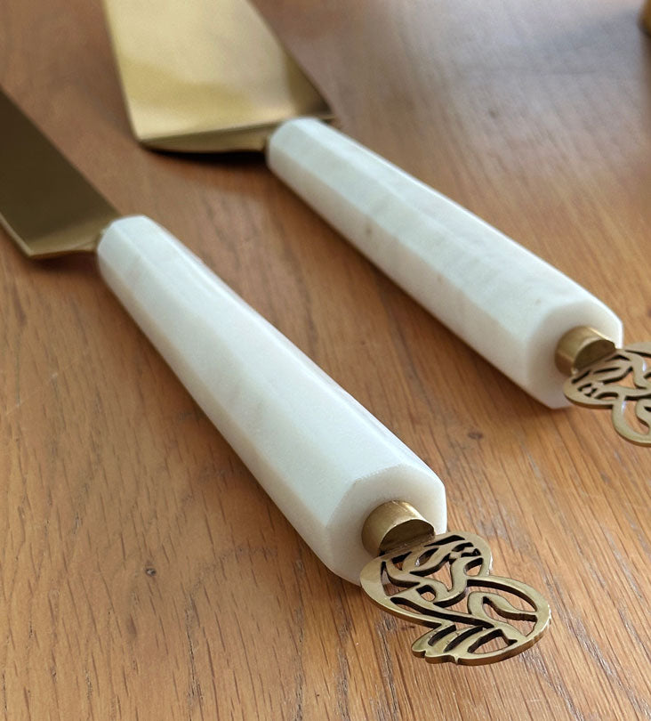 Elegant cake knife and servers made with marble and brass featuring Arabic calligraphy designs.