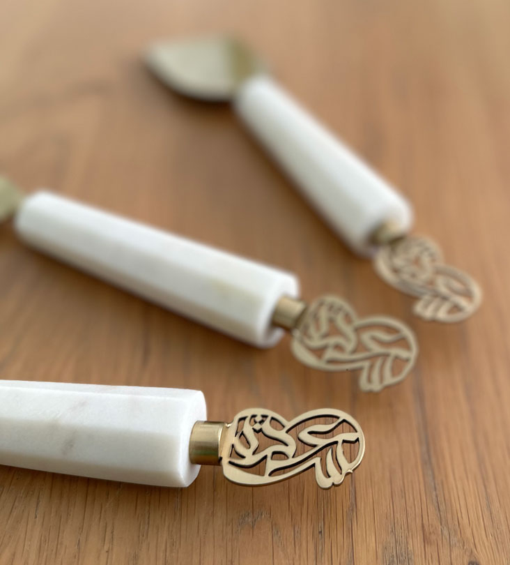 Elegant cheese knives set made with marble and brass featuring Arabic calligraphy designs.