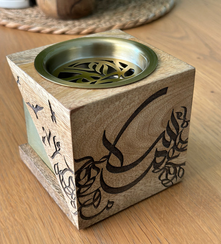 Cube-shaped incense burner made with wood and brass featuring Arabic calligraphy etchings, designed by Kashida.