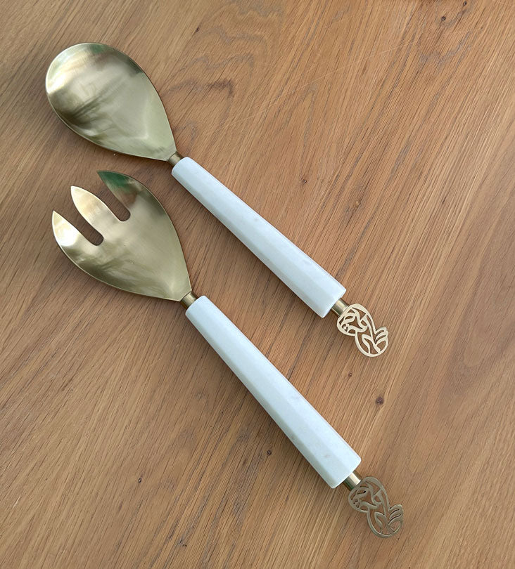 Elegant salad servers made with marble and brass featuring Arabic calligraphy designs.