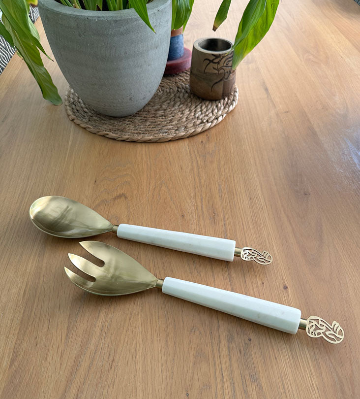 Elegant salad servers made with marble and brass featuring Arabic calligraphy designs.