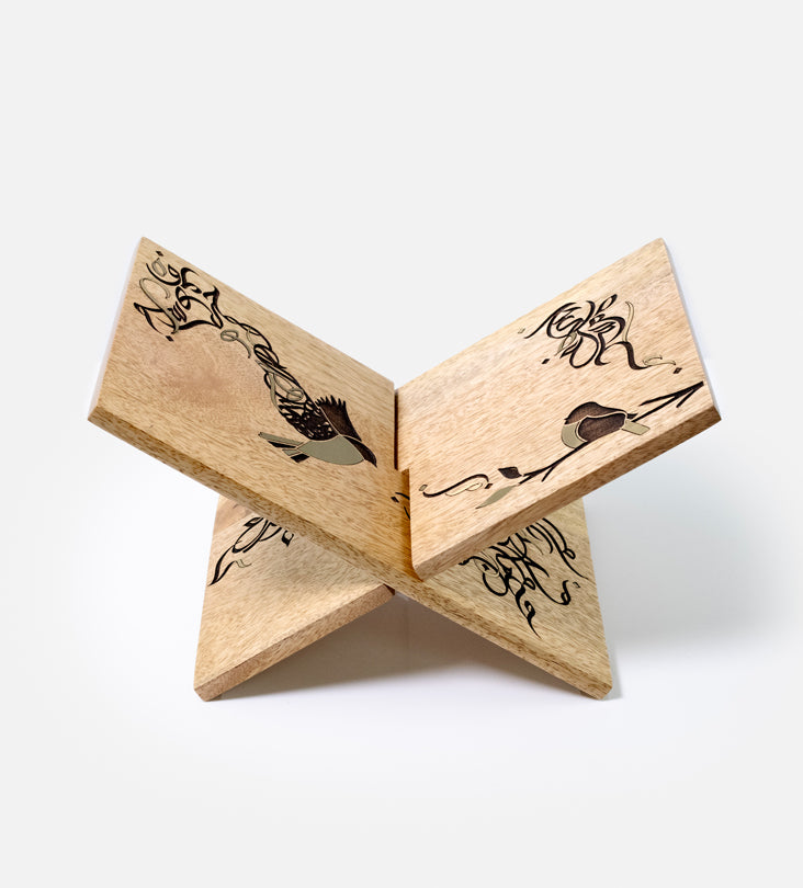 Handmade wooden quran holder featuring artwork of birds merged with Arabic calligraphy made with brass inlay