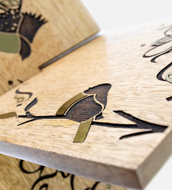 Handmade wooden quran holder featuring artwork of birds merged with Arabic calligraphy made with brass inlay