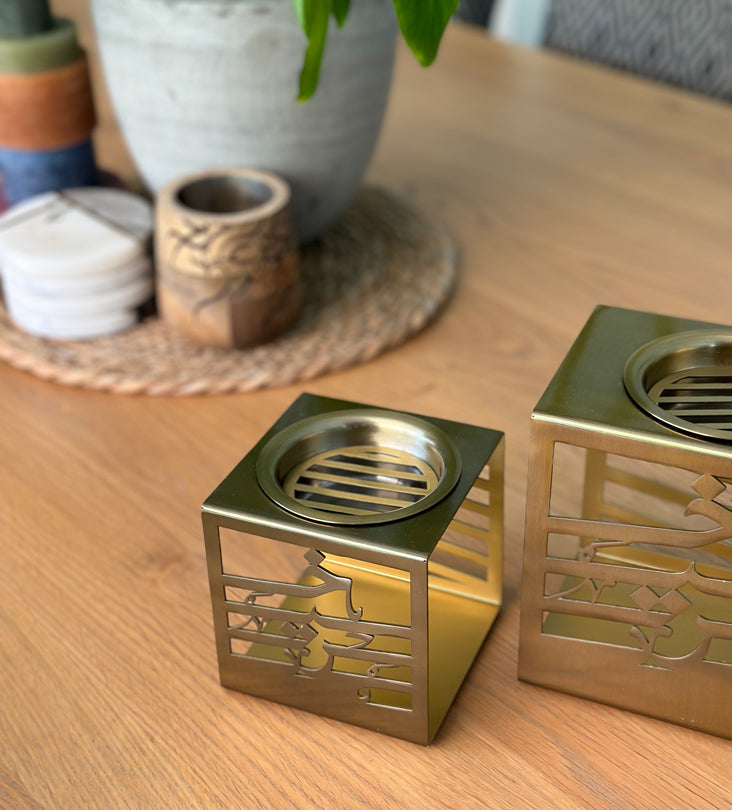 Cuboid metal incense burner made with brass sheet and Arabic calligraphy words cut through, designed by Kashida.