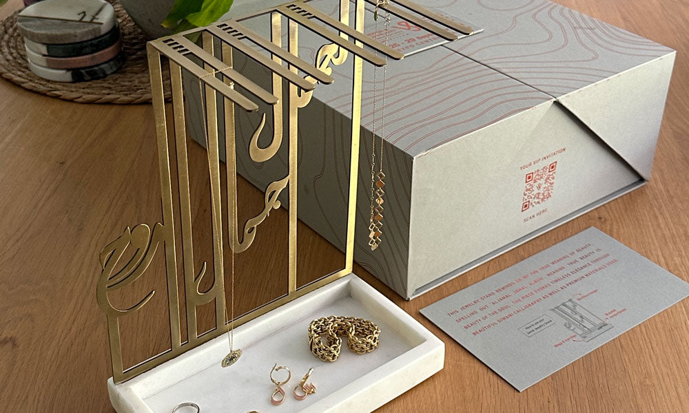 VIP invitation gift for Sharjah Jewelry and Watch Expo, featuring a marble and brass jewelry stand in Arabic calligraphy, designed by Kashida