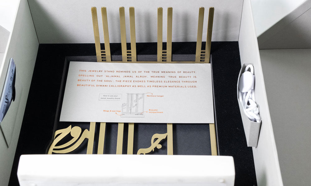 VIP invitation gift for Sharjah Jewelry and Watch Expo, featuring a marble and brass jewelry stand in Arabic calligraphy, designed by Kashida