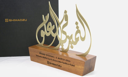 Arabic calligraphy trophy design by Kashida featuring laser cut metal on a solid wooden base