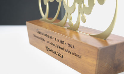 Arabic calligraphy trophy design by Kashida featuring laser cut metal on a solid wooden base