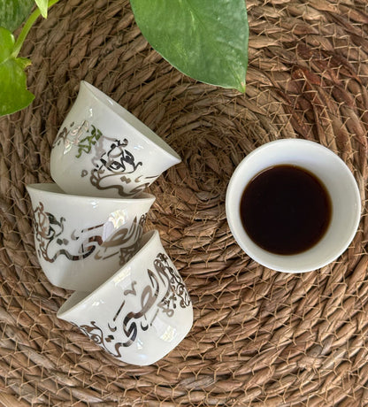 Elegant silver qahwa coffee cups featuring Arabic calligraphy designs by Kashida.