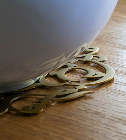 Elegantly etched round trivet with Arabic graffiti letters